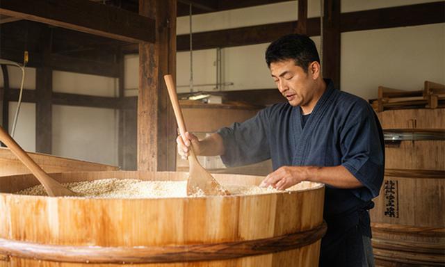 岩手の日本酒蔵で木桶を囲み仕込み作業をする杜氏